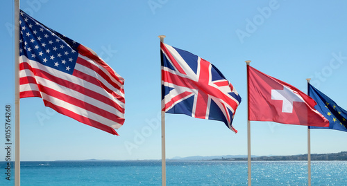 The flags of the United States, Great Britain, Switzerland, and the European Union in the wind at the coast of Nice, France