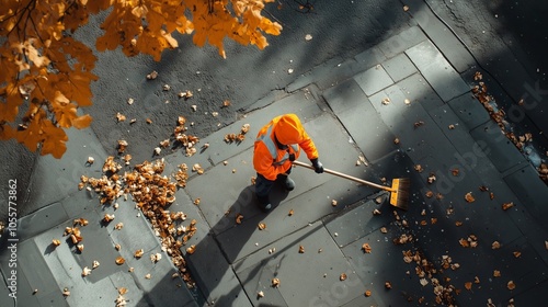 Street cleaner sweeping fallen autumn leaves on sidewalk photo