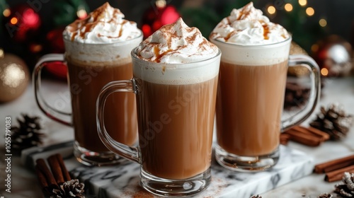 Three tall glasses filled with warm coffee topped with cinnamon whipped milk foam and caramel arranged on a marble board with festive decorations