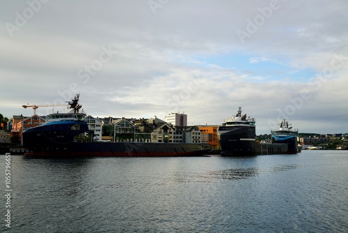 View of Large ships docked at a harbor with a cloudy sky in the background