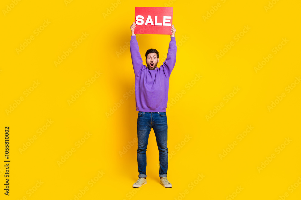 Full length photo of nice young male amazed hold raise sale plate dressed stylish violet garment isolated on yellow color background Full length photo of nice young male amazed hold raise sale plate dressed stylish violet garment isolated on yellow color background