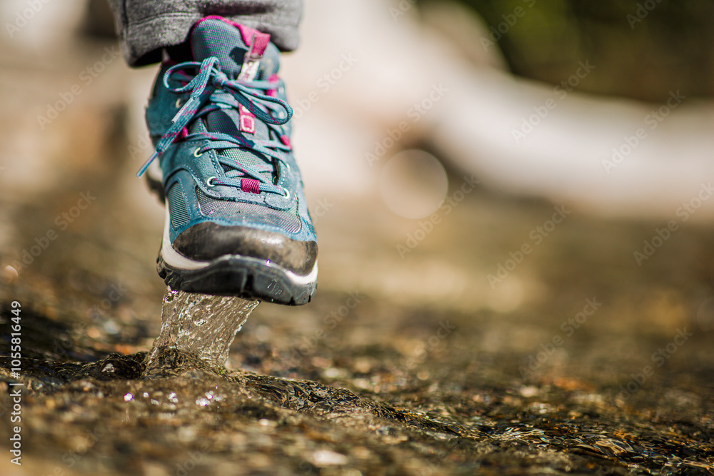 Close-up of hiking shoe splashing through shallow water Close-up of hiking shoe splashing through shallow water