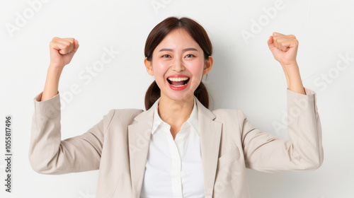 Triumphant Businesswoman: A portrait of a joyful Asian businesswoman celebrating success with raised fists. Her radiant smile and confident posture exude power and achievement.