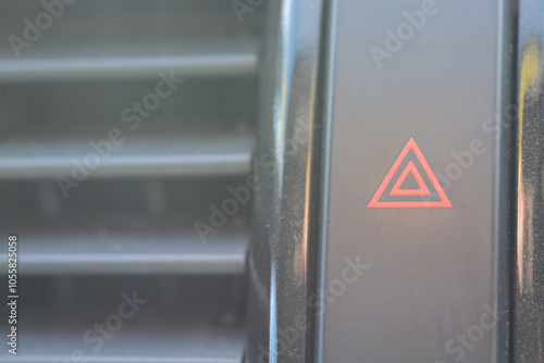 The image showcases the car's hazard warning light button, easily recognizable with its red triangle symbol on a black background. photo