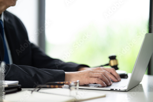 On the desk of a lawyer working with a notebook is working on documents to prepare for a lawsuit