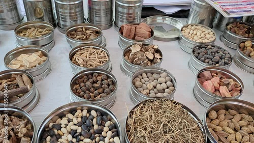 A wide view of Ayurvedic herbs and roots is displayed at a roadside herbal stall