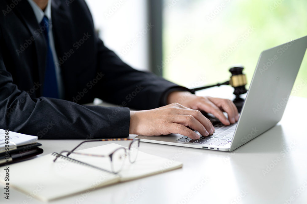 On the desk of a lawyer working with a notebook is working on documents to prepare for a lawsuit On the desk of a lawyer working with a notebook is working on documents to prepare for a lawsuit