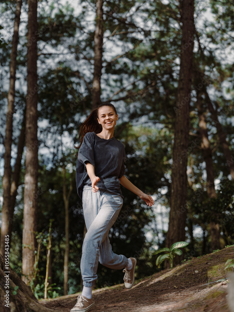 Happy young woman running through a forest trail, enjoying nature and outdoor activity with a joyful expression on her face Freedom and adventure concept Happy young woman running through a forest trail, enjoying nature and outdoor activity with a joyful expression on her face Freedom and adventure concept