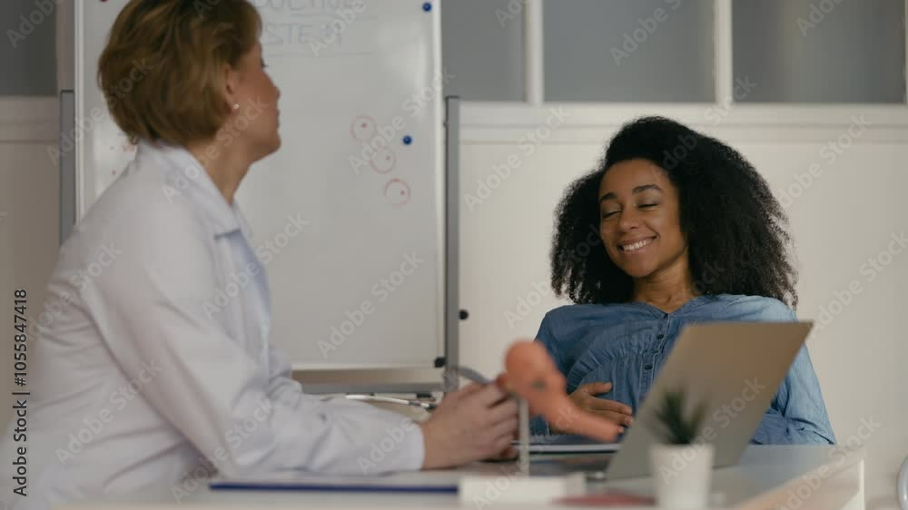 Happy pregnant woman talking with obstetrician during hospital consultation Happy pregnant woman talking with obstetrician during hospital consultation