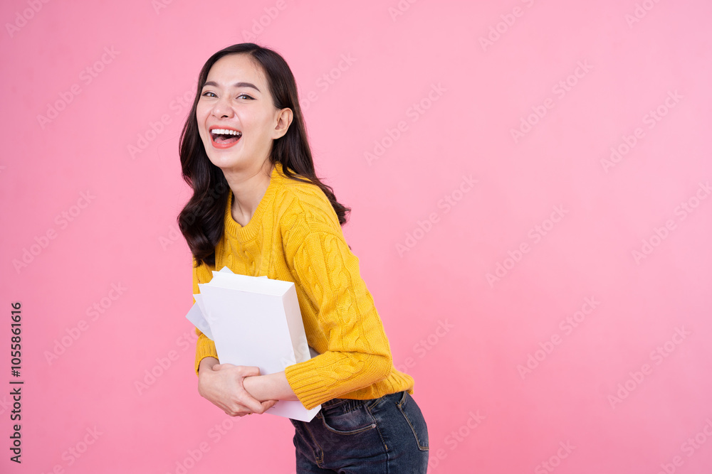 Young asian women holds books and smile isolated on pink background. Happy woman student. Education concept Young asian women holds books and smile isolated on pink background. Happy woman student. Education concept