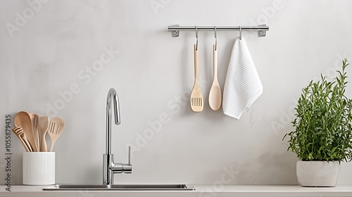 Modern kitchen interior featuring wooden utensils, a clean countertop, and fresh herbs by the sink in a minimalist setting photo