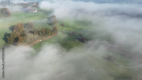 Aerial shot showing a low level mist at sunrise over countryside