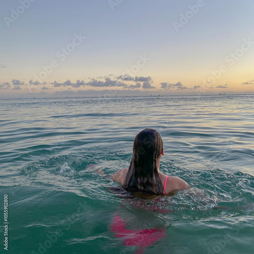 Woman Swimming in Tranquil Ocean at Sunset