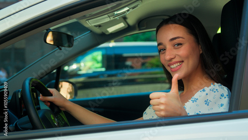 Happy female car owner Caucasian woman girl buyer smiling driver sitting inside rent automobile driving auto looking at camera showing thumb up recommend test drive buying vehicle transport travelling