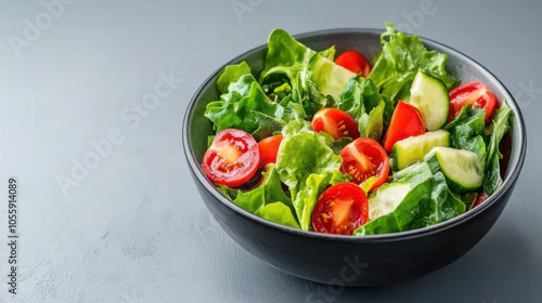 Fresh salad with leafy greens, tomatoes, and cucumbers in bowl, showcasing vibrant colors and healthy ingredients. Perfect for nutritious meal or snack