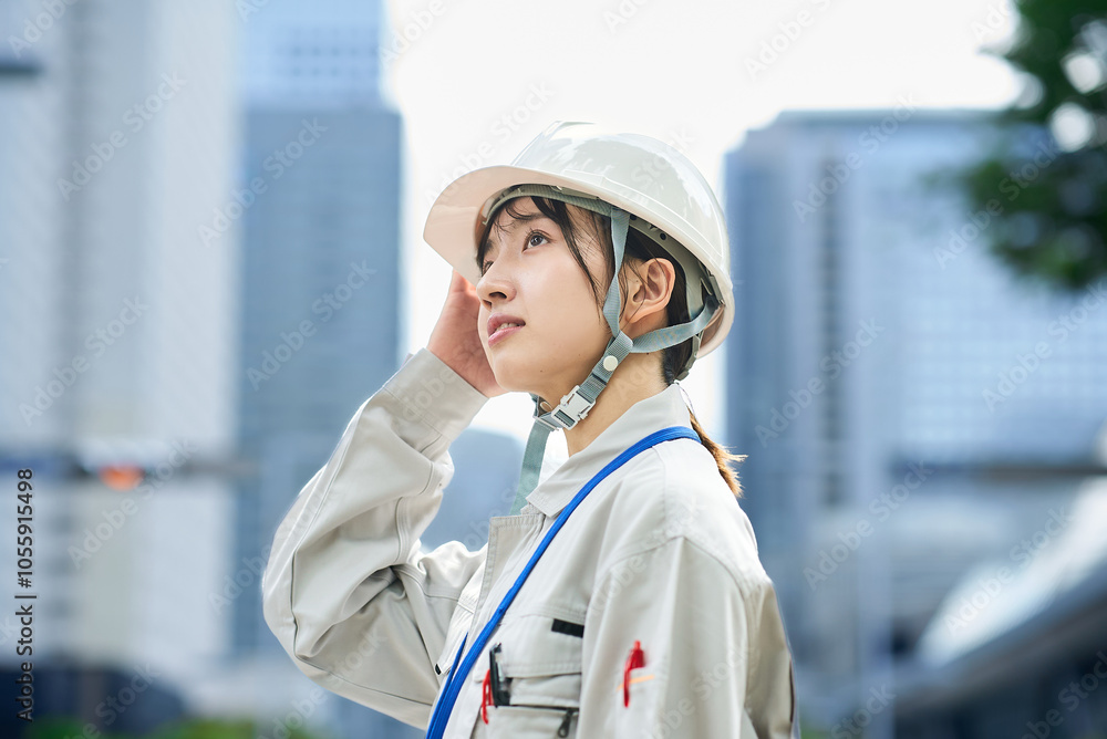 作業服とヘルメットを着用した若い女性 作業服とヘルメットを着用した若い女性