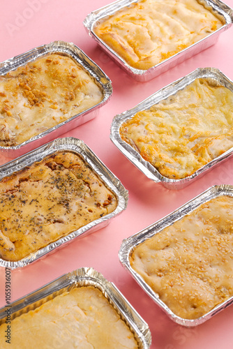 Various chicken pies on pink background photo