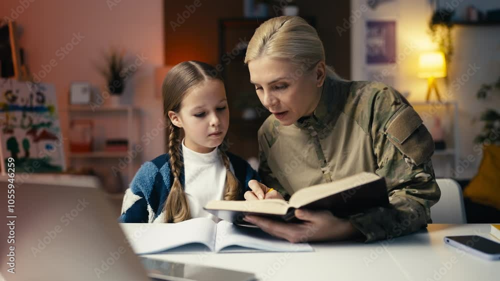 Military mom explaining homework task to little daughter, togetherness, family Military mom explaining homework task to little daughter, togetherness, family
