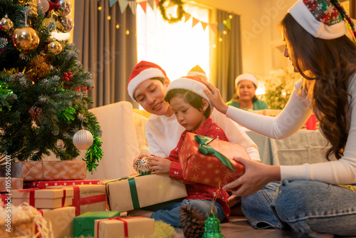 A joyful family gathers around beautifully decorated Christmas tree, sharing excitement of gift giving. warm atmosphere is filled with love and holiday spirit
