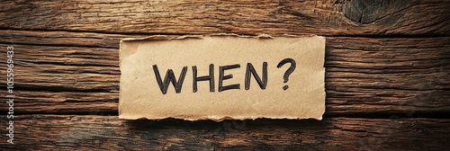 A visually engaging paper displaying 'WHEN?' placed on a textured wooden background, encouraging the viewer to think about time, decisions, and introspection.