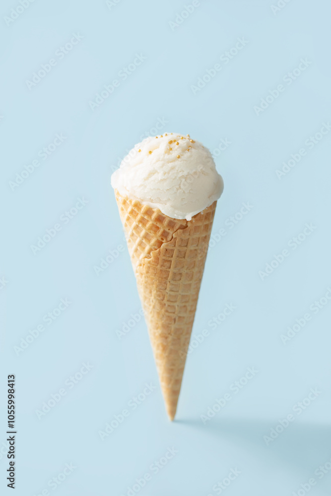 Vanilla ice cream ball in a waffle cone on a blue background Vanilla ice cream ball in a waffle cone on a blue background
