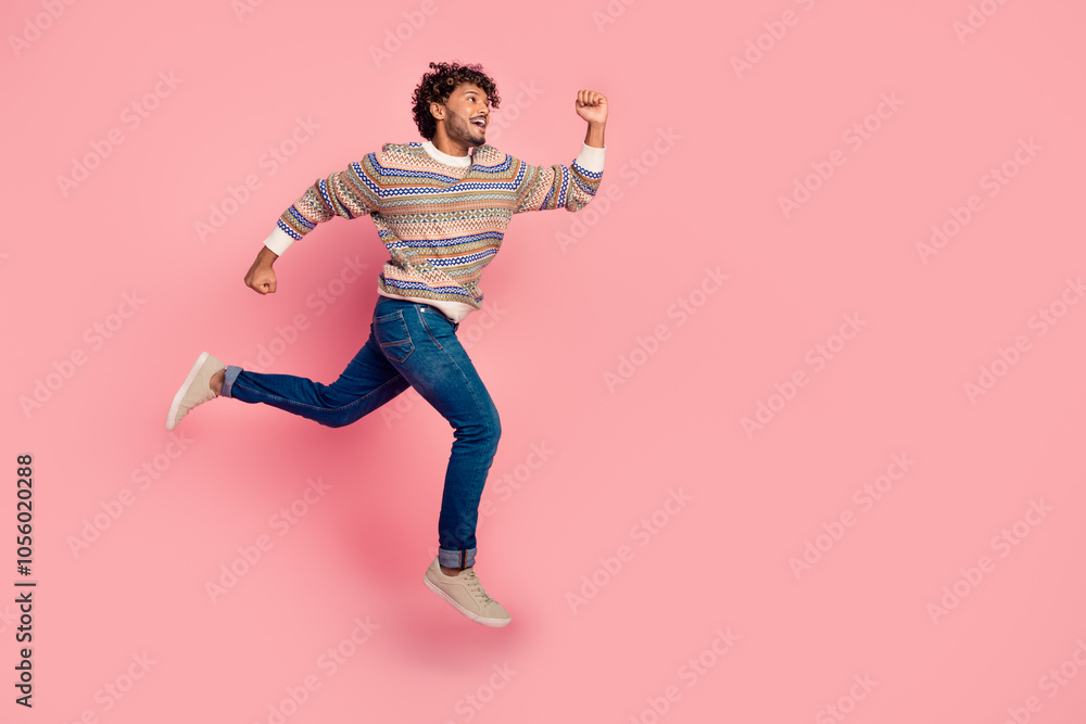 Full body profile portrait of nice young man jump run empty space wear sweater isolated on pink color background Full body profile portrait of nice young man jump run empty space wear sweater isolated on pink color background