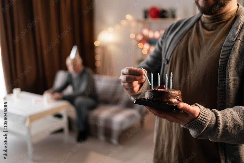 Cropped photo of a plate with birthday cake and candles in man's hands