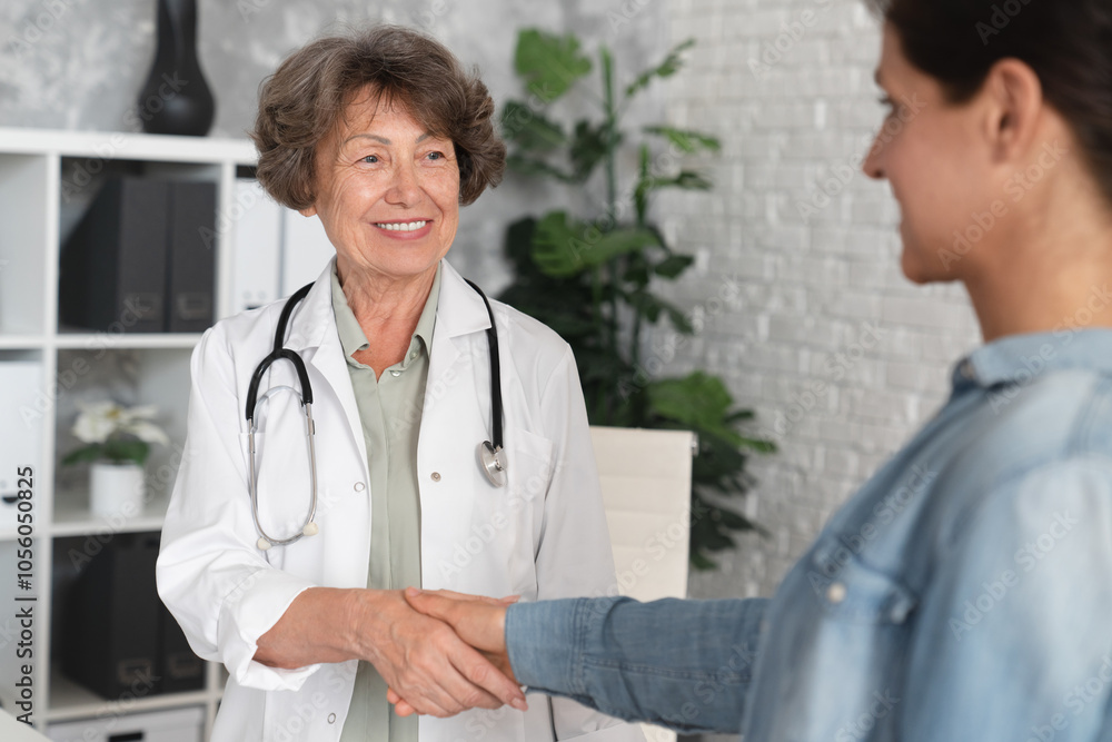 Doctor therapist gynecologist shaking hands with female mature patient. Successful treatment, recuperation and treatment. Healing process in hospital Doctor therapist gynecologist shaking hands with female mature patient. Successful treatment, recuperation and treatment. Healing process in hospital