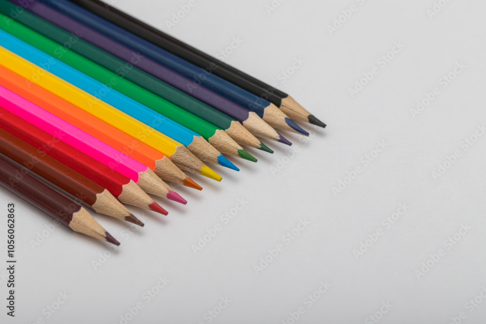 Colored crayons on a white background. The crayons are brown, black, yellow, orange, blue, purple Colored crayons on a white background. The crayons are brown, black, yellow, orange, blue, purple