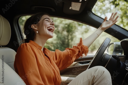 Joyful woman leaning out of car window, laughing photo