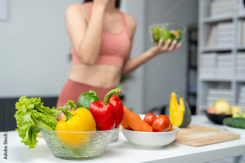A woman is holding a bowl of vegetables in front of a table A woman is holding a bowl of vegetables in front of a table