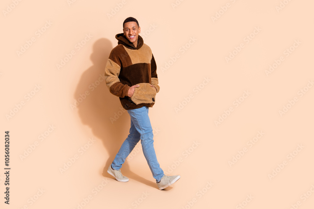Full length photo of good mood nice man wear stylish clothes walking empty space isolated on beige color background Full length photo of good mood nice man wear stylish clothes walking empty space isolated on beige color background