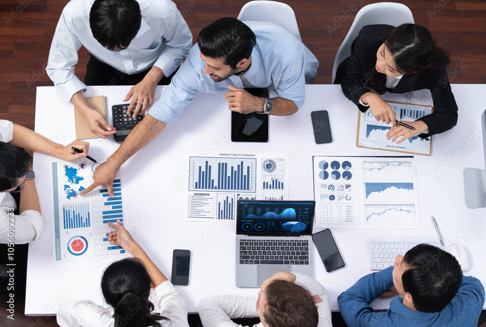 Naklejka premium Top view analyst team utilizing BI Fintech to analyze financial data at table in meeting room. Analytic BI dashboard power on paper for business insight and strategic marketing planning. Prudent