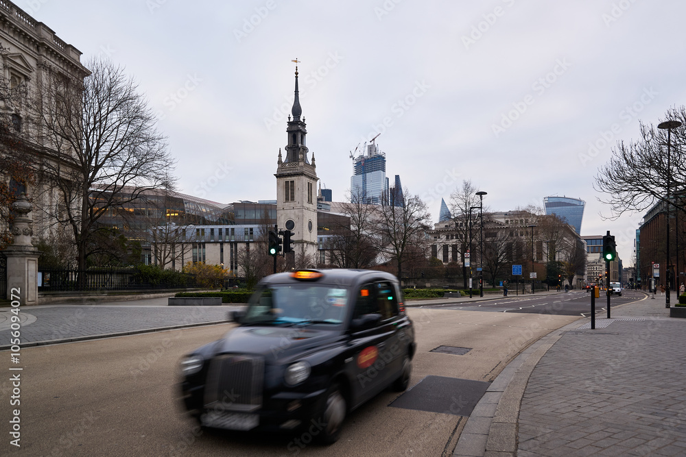 London taxi in motion blur with the city skyline behind driving on a street London taxi in motion blur with the city skyline behind driving on a street