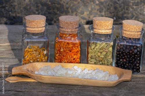 Mastic tears in a wooden bowl with botanicals in glasses. photo