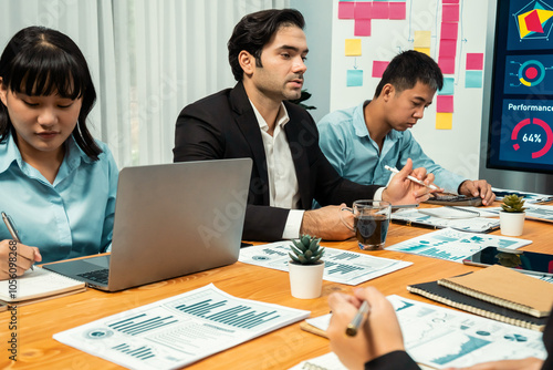 Diverse group of business analyst team analyzing financial data report. Finance data analysis chart and graph dashboard show on TV screen in meeting room for strategic marketing planning. Habiliment