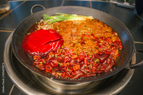 Table top view of Mala seasoning spicy Chinese hotpot. Hotpot is an interactive meal in which diners sit around a simmering pot of soup at the center of the table with ingredients. 