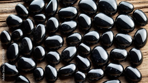 High-resolution photo of apache tears on wood. These volcanic stones are known for grounding and protection, suitable for creative projects featuring mineral energy or crystal collections. photo