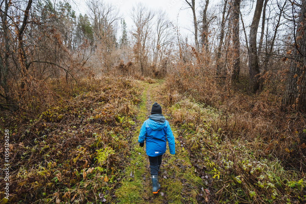 A cheerful person wearing a bright blue jacket leisurely strolls through tranquil woods, fully embracing and enjoying the stunning beauty and serene atmosphere of the surrounding nature A cheerful person wearing a bright blue jacket leisurely strolls through tranquil woods, fully embracing and enjoying the stunning beauty and serene atmosphere of the surrounding nature
