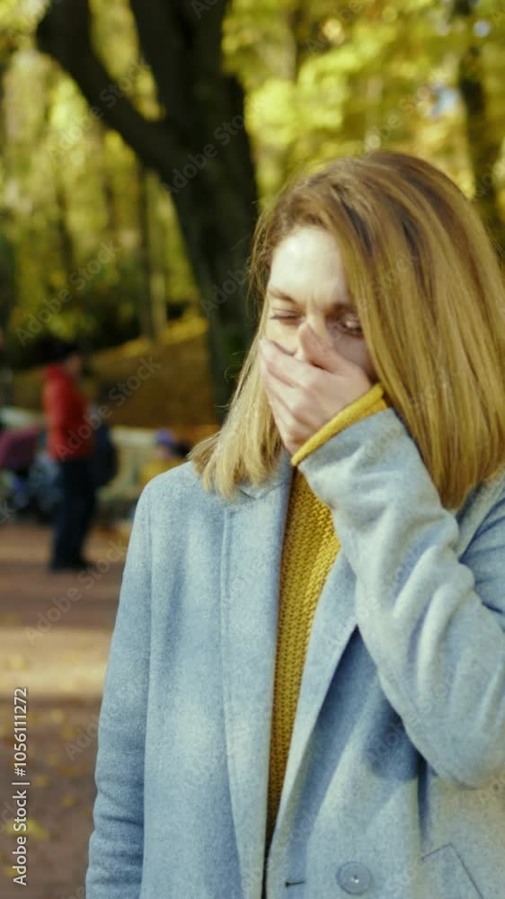 Attractive young woman having headache feel unhappy stand in autumn park at sunlight. Blonde stressed lady. Portrait pain tired. Sick. Close up. Slow motion