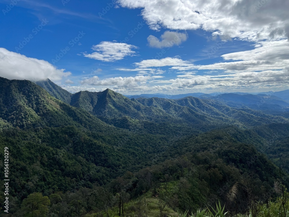 A breathtaking view of rolling mountains under a blue sky adorned with clouds, capturing the beauty of nature in a serene landscape A breathtaking view of rolling mountains under a blue sky adorned with clouds, capturing the beauty of nature in a serene landscape
