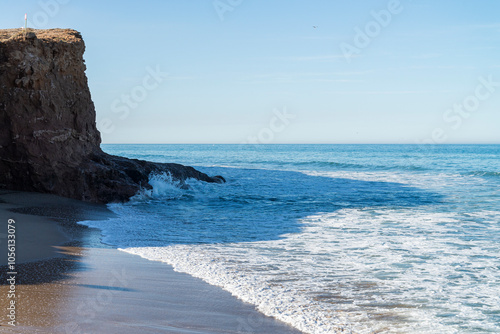 Playa y oleaje con acantilado photo