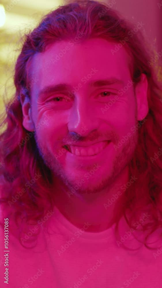 Portrait of attractive young bearded man in purple interior pink neon lights smiling happy to camera staying home. Portrait of attractive young bearded man in purple interior pink neon lights smiling happy to camera staying home.