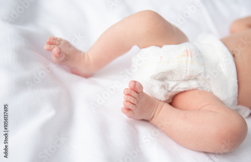 The scene captures a serene baby at rest, with delicate limbs and tiny toes gently resting on a plush, white fabric, evoking warmth and innocence during a tranquil afternoon.