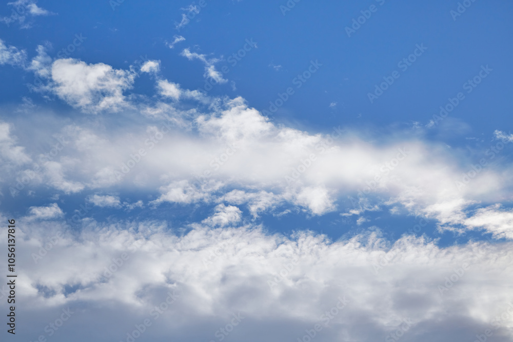 White cumulus and cirrus clouds in the blue sky
