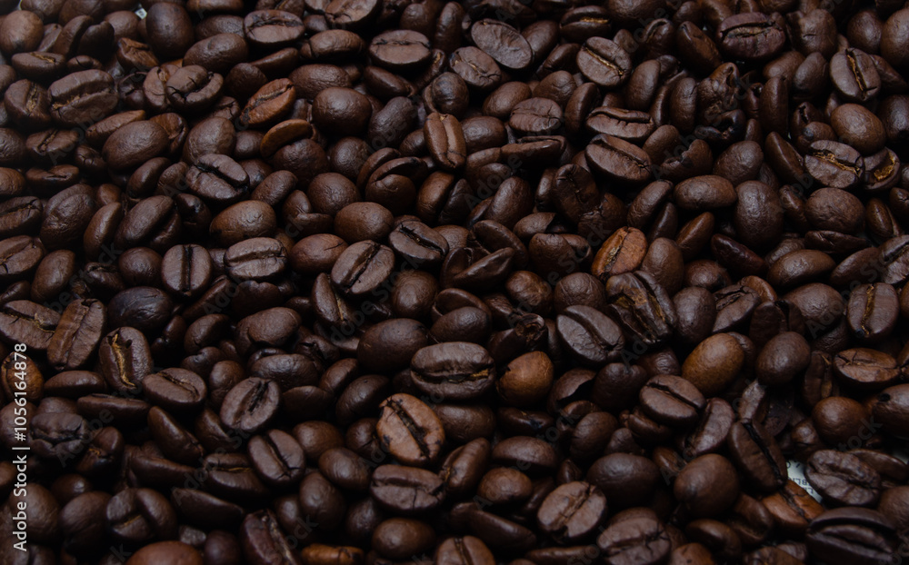 A pile of coffee beans. All stacked together, waiting to be ground into a delicious cup of coffee. A close-up shot of roasted coffee beans. Different types of delicious coffee beans. A pile of coffee beans. All stacked together, waiting to be ground into a delicious cup of coffee. A close-up shot of roasted coffee beans. Different types of delicious coffee beans.