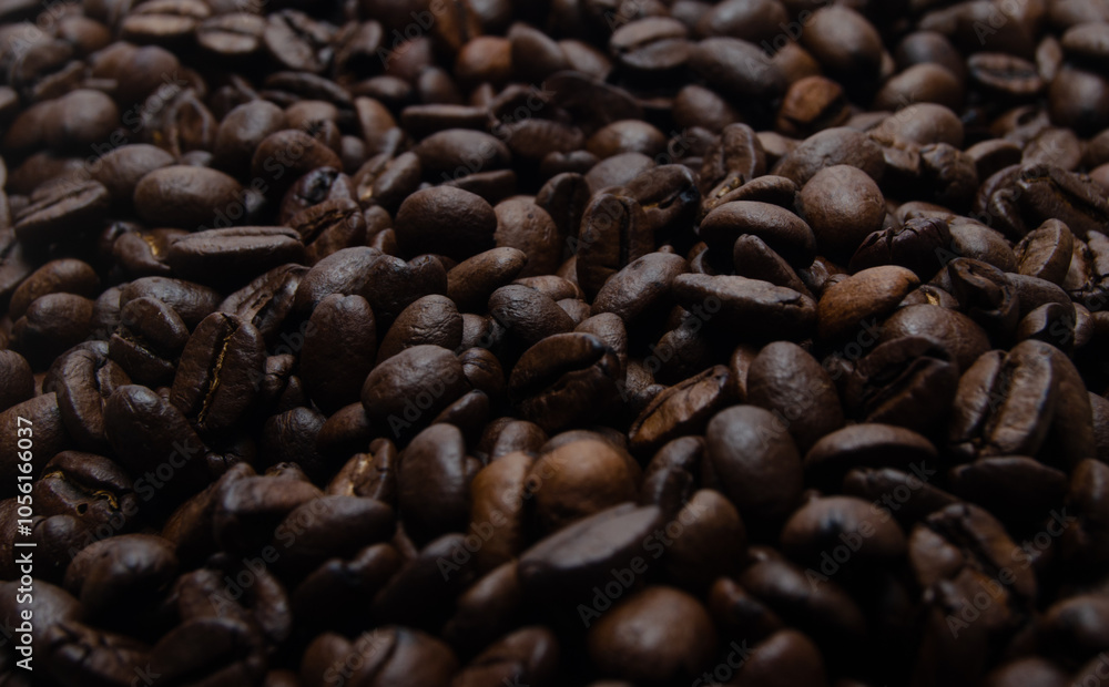 A pile of coffee beans. All stacked together, waiting to be ground into a delicious cup of coffee. A close-up shot of roasted coffee beans. Different types of delicious coffee beans. A pile of coffee beans. All stacked together, waiting to be ground into a delicious cup of coffee. A close-up shot of roasted coffee beans. Different types of delicious coffee beans.