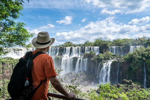 Hombre viajero, con sombrero y mochila, contemplando las vistas de las Cataratas del Iguazú, en Argentina