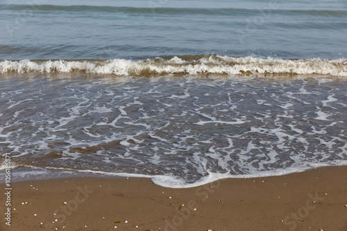 Beach with waves and white foam on the sand and sea background. Caspian Sea photo