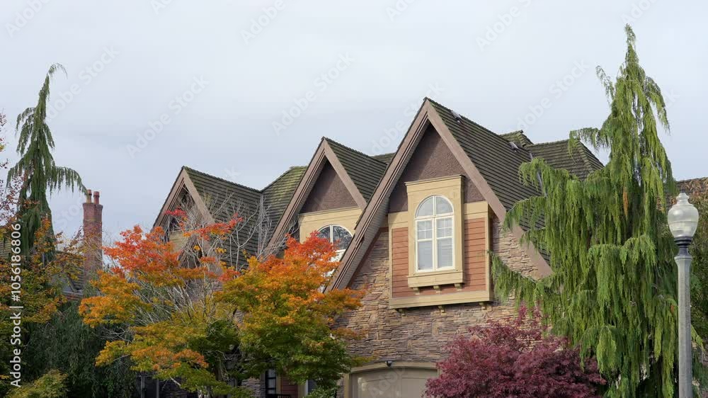 Establishing shot. Top of grey stucco luxury house with shingle roof, red and yellow trees and nice windows in Fall in Vancouver, Canada, North America. Day time on October 2021. Still camera view. Pr Establishing shot. Top of grey stucco luxury house with shingle roof, red and yellow trees and nice windows in Fall in Vancouver, Canada, North America. Day time on October 2021. Still camera view. Pr